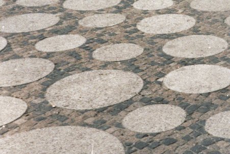 Das Foto zeigt das Podium mit den alten Pflastersteinen und den runden Waschbetonplatten.