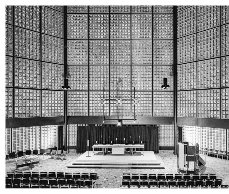 Das historische Foto zeigt den Altarbereich der Kirche mit einem schlichten Kreuz, das Egon Eiermann gestaltet hat.
