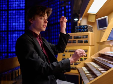 Ein Foto zeigt den Organisten Sebastian Heindl an der Orgel. 