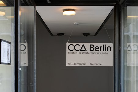 Das Foto zeigt das Foyer-Gebäude von innen mit seinen gläsernen Wänden und Holzvertäfelungen. 